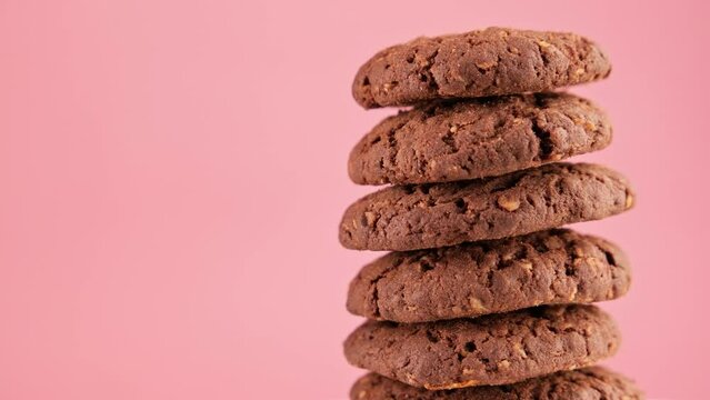 Stack of tasty cookies rotating on pink background. Homemade food concept with copy space. Rotating fresh cookies. Tasty bakery dessert. Healthy food. Close-up in 4K, UHD