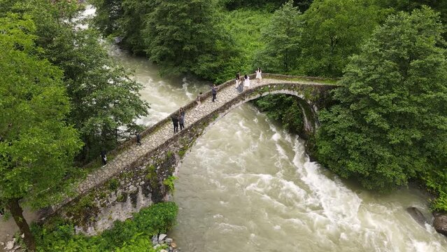 Aerial view of the historical stone arch bridge in the forest.