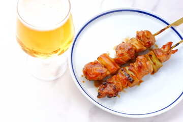 炭火焼にしたタレの焼き鳥（ねぎま）をつまみにビールを飲む