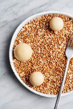 Fine dining plated dessert of popped buckwheat with salted caramel ice cream