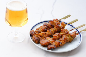 炭火焼の焼き鳥（タレ）をつまみにビールを飲む