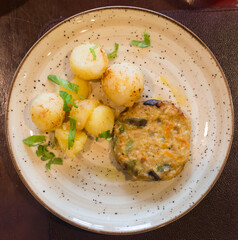 squash burger with boiled potatoes on a plate. top view