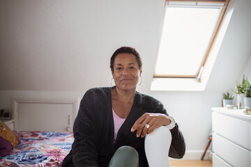 Portrait confident mature woman in sunny bedroom