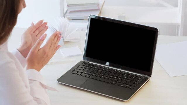 Successful online cooperation. Video call. Good job. Unrecognizable proud business woman applauding at blank notebook with mockup copy space black display.