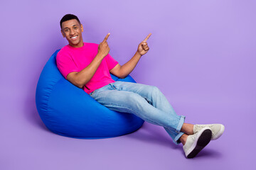 Full length photo of positive nice man two muscular arm direct empty space offer stylish clothes shop isolated on purple color background