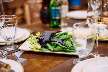 Laid table in the restaurant. Lunch break. Greens on the table in the restaurant.