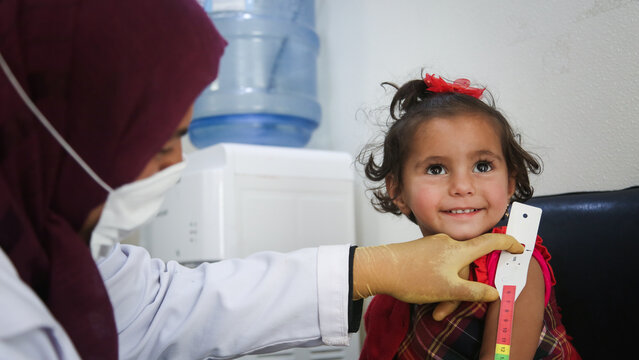 Doctor examines child malnutrition. Measuring malnutrition using strap MUAC mid-upper-arm-circumference.