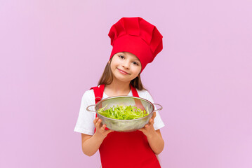 A little girl wants to cook a new dish of fresh salad on an isolated background.