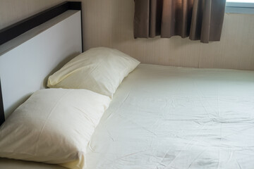 Plain light yellow bed and pillow in the bedroom at cozy home