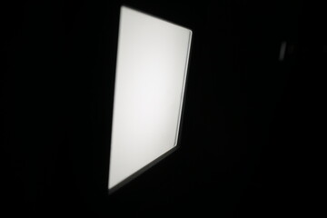 Schwarze Betonfassade mit weißer quadratischer eingebauter leuchtender Lampe in der Nacht in Stadt...