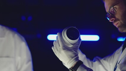 Professional scientists in white coats working inside modern futuristic laboratory .  Construction experts doing experiment . Physician or seismologist testing inside lab . Concept of quality checking