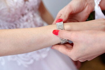 Diamond bracelet put on the bride's hand by mom