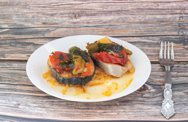 Delicious traditional Turkish fish dish, Palamut Pilaki. Presentation of a great fish dish on a white plate. top shot.