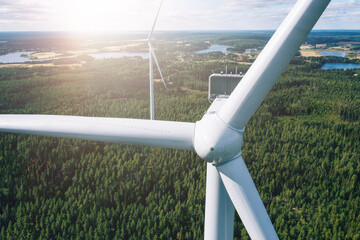 Aerial view of windmills in summer forest in Finland. Wind turbines for electric power with clean...