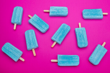 blue popsicles on a pink background