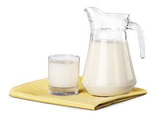 A glass of milk and a milk jug on plaid tablecloth