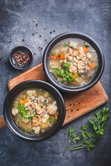 Mushrooms transparent  soup with champignon, vegetables and pearl barley. Simple and hearty cuisine for the cold season. Forest food, vegan proteins. Baltic cuisine