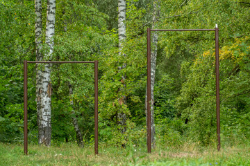 Homemade old horizontal bars on the background of trees. Do-it-yourself sports equipment.