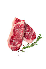 Two juicy raw beef striploin steaks isolated on a white background with herbs and spices, top view