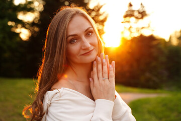 Beautiful woman. Happy girl at sunset. Hands near face. Femininity concept. Portrait