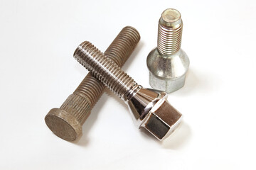 Different bolts with nuts scattered on a white background. Bolts on a white background