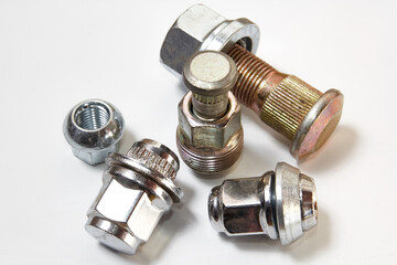 Different bolts with nuts scattered on a white background. Bolts on a white background