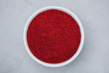 Obraz na płótnie Canvas Chilli powder. Smoked chilli paprika. Red chilli powder paprika in bowl on gray stone background.