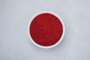 Obraz na płótnie Canvas Chilli powder. Smoked chilli paprika. Red chilli powder paprika in bowl on gray stone background.