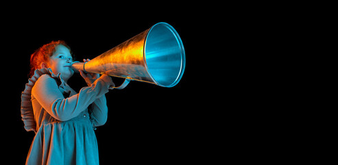 Studio shot of little girl, kid in elegant dress holding huge retro megaphone isolated over dark background. News, sales, emotions