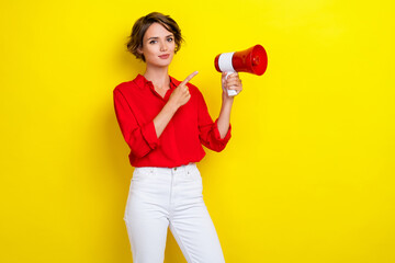 Photo of gorgeous lovely girl with bob hairstyle wear red shirt hold finger indicating megaphone isolated on yellow color background