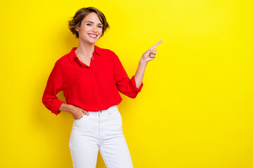 Portrait of lovely adorable positive girl with bob hairdo dressed red shirt directing empty space...
