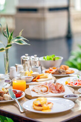 Table full of delicious food - cheese, salmon, ham, bakery and juices