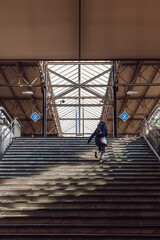 Woman running up the stairs to catch a train