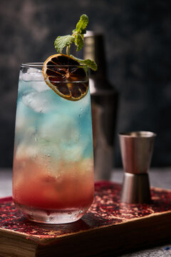Rainbow paradise cocktail garnished with orange