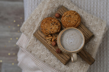 A cup of coffee and cookies on a tray on the bed. Autumn cozy composition. Hygge lifestyle, cozy autumn mood