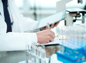 science lab technician with a digital tablet making notes on the clipboard.