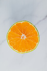 Tangerine cut in half and photographed close up on marble background 
