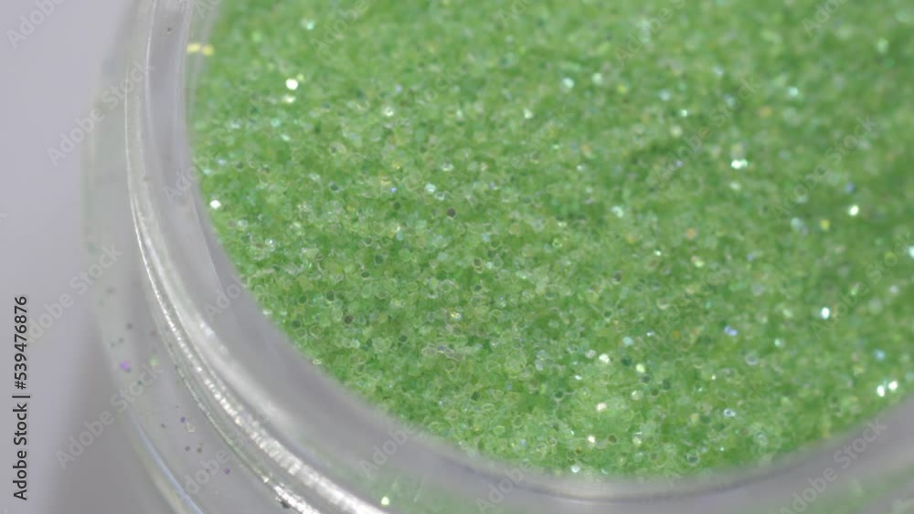Poster green sequins in a jar rotate in a circle