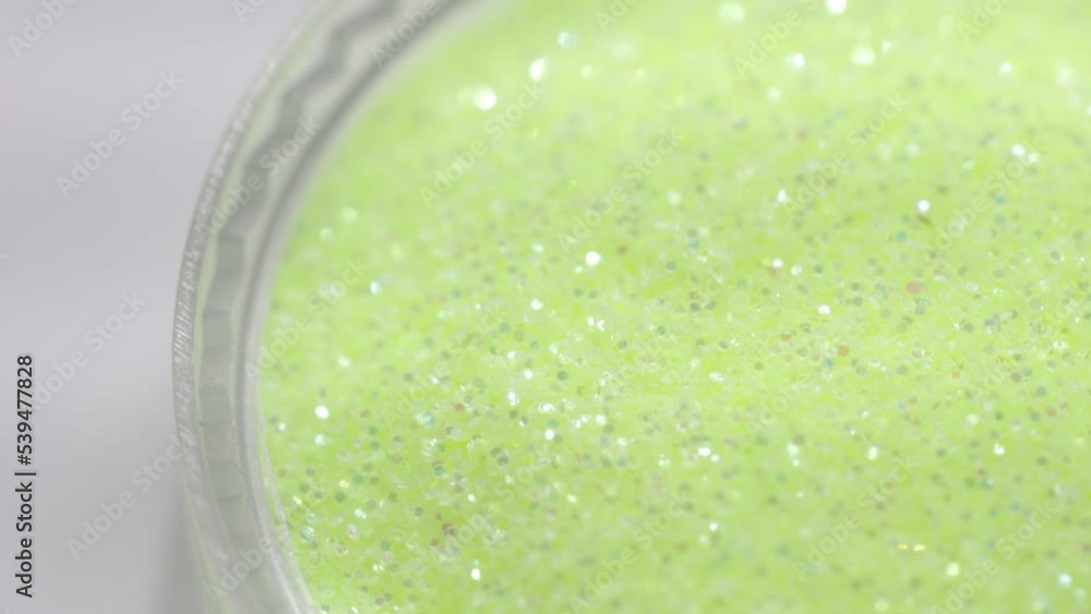 Poster green sequins in a jar rotate in a circle