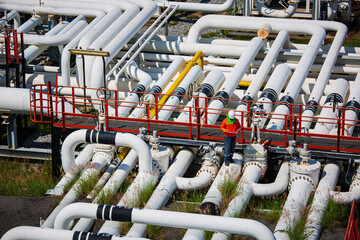 Male worker inspection at steel long pipes and pipe elbow valve in station oil factory during refinery valve of visual check record pipeline oil