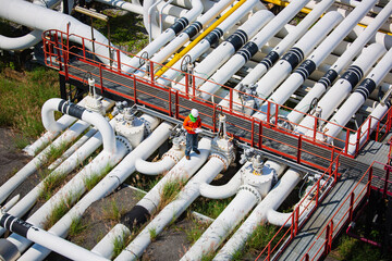 Top view male worker inspection at steel long pipes and pipe elbow valve in station oil factory during refinery valve of visual check record pipeline oil