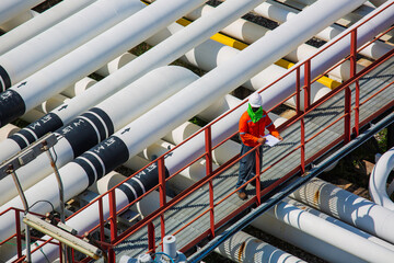 Top view male worker inspection at steel long pipes and pipe elbow valve in station oil factory during refinery valve of visual check record pipeline oil