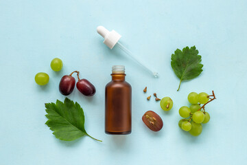 Bottle of grape seed essential oil with grapes. Eco cosmetic product