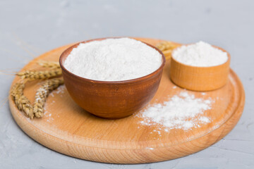 Flat lay of Wheat flour in wooden bowl with wheat spikelets on colored background. world wheat crisis