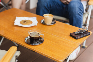 Hot americano coffee with cappuccino coffee on wooden table.