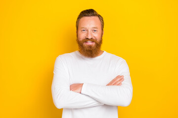 Portrait photo of young successfull experienced redhair beard man wear white long sleeve folded hands isolated on yellow color background