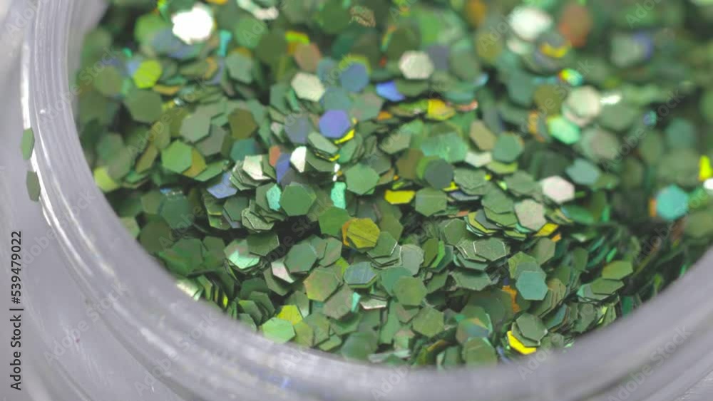 Poster green sequins in a jar rotate in a circle