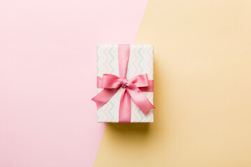 holiday paper present tied pink ribbon bow top view with copy space. Flat lay holiday background. Birthday or christmas present. Christmas gift box concept with copy space