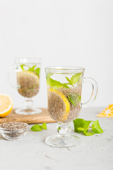 Healthy breakfast or morning with chia seeds lemon and mint on table background, vegetarian food, diet and health concept. Chia pudding with lemon and mint