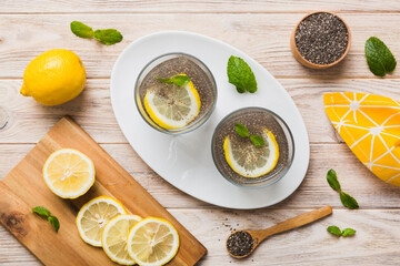 Healthy breakfast or morning with chia seeds lemon and mint on table background, vegetarian food, diet and health concept. Chia pudding with lemon and mint